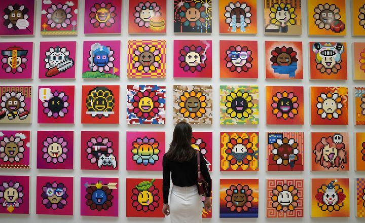 Une personne se tient devant le projet NFT de l'artiste Takashi Murakami appelé Murakami Flowers lors de l'avant-première de presse du 11 mai 2022 pour "An Arrow through History" aux galeries Gagosian de New York. (TIMOTHY A. CLARY / AFP)