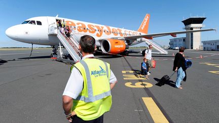 Des passagers descendent d'un avion de la compagnie EasyJet, le 25 juillet 2009, &agrave; La Rochelle (Charente-Maritime). (REMY GABALDA / AFP)