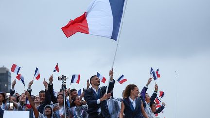 Florent Manaudou porte le drapeau de la délégation tricolore lors de la cérémonie d'ouverture le 26 juillet 2024. (FRANCK FIFE / POOL)