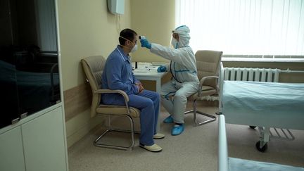 Sur cette photo fournie par le ministère de la Santé russe,&nbsp;un médecin examine un participant à un essai de vaccin contre le Covid-19, à l'hôpital militaire de Moscou, le 20 juillet 2020.&nbsp; (MINISTRY OF DEFENCE OF RUSSIA / AFP)