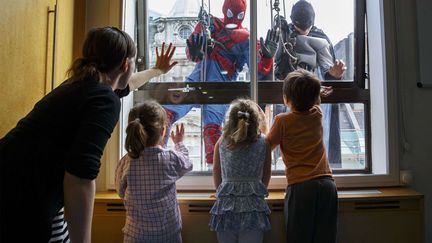 Deux laveurs de carreaux sont d&eacute;guis&eacute;s en superh&eacute;ros pour amuser les enfants de l'h&ocirc;pital Portland &agrave; Londres (Royaume-Uni), le 22 octobre 2014. (TOLGA AKMEN / REX / SIPA)