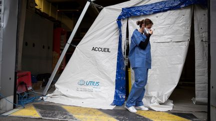 Une membre du personnel soignant de l'hôpital Henri Mondor à Créteil, le 6 mars 2020, avant d'effectuer une prise de sang à des patients présentant des symptômes du Covid-19. (THOMAS SAMSON / AFP)