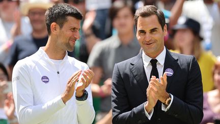 Le Serbe Novak Djokovic et le Suisse Roger Federer lors&nbsp;d'une cérémonie pour le centenaire du Centre Court, à Wimbledon, le 3 juillet 2022. (TAKUYA MATSUMOTO / YOMIURI via AFP)