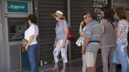 Des Grecs font la queue devant un distributeur, le 6 juillet 2015. (ROBERT GEISS / PICTURE ALLIANCE / AFP)