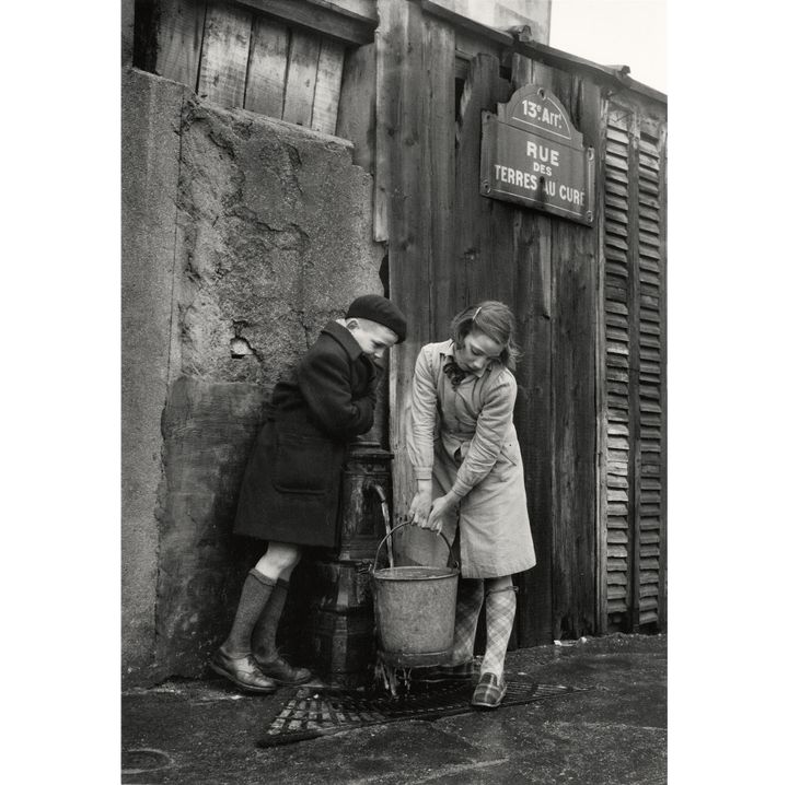 Sabine Weiss, Enfants prenant de l'eau à la fontaine, rue des Terres-au-Curé, Paris, 1954
 (Sabine Weiss)