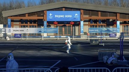 Un&nbsp;travailleur&nbsp;pulvérise un désinfectant à titre préventif contre le Covid-19,&nbsp;le 3 février 2022, près de Yanqing (Chine), ville qui accueille&nbsp;des épreuves&nbsp;aux Jeux olympiques d'hiver de Pékin. (DIMITAR DILKOFF / AFP)