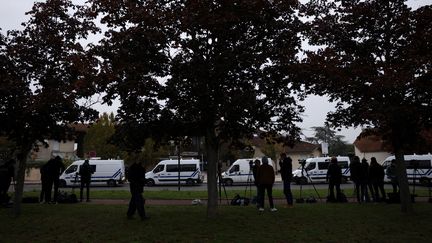 Policiers et journalistes le 17 octobre 2020 devant le collège de Conflans-Sainte-Honorine, où enseignait Samuel Paty. (YOAN VALAT / EPA / MAXPPP)