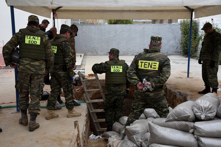 Une équipe de démineurs a pied d'oeuvre autour du trou où une&nbsp;bombe de la Seconde guerre mondiale a été trouvée, à Thessalonique (Grèce), le 12 février 2017. (ALEXANDROS AVRAMIDIS / REUTER)