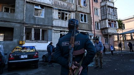 Des policiers devant un immeuble visé par des tirs d'artillerie lourde à Stepanakert, dans le Haut-Karabah, le 3 octobre 2020. (AFP)