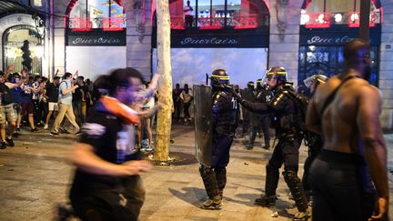 Des CRS interviennent sur les Champs-Elysées, à Paris, le 15 juillet 2018. (ERIC FEFERBERG / AFP)