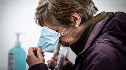 Un test salivaire pratiqué sur une femme à Saint-Etienne (Loire), le 22 février 2021. (JEAN-PHILIPPE KSIAZEK / AFP)