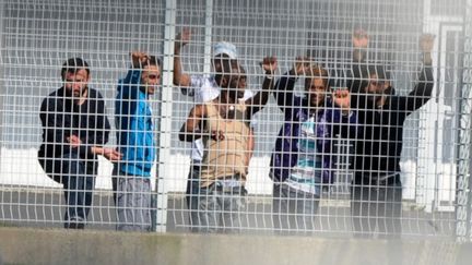 Des clandestins derri&egrave;re les grilles d'un centre de r&eacute;tention, &agrave; Saint-Jacques-de-la-Lande, pr&egrave;s de Rennes, le 15 mars 2012.&nbsp; (FRANK PERRY / AFP)