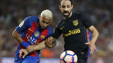 Neymar et Juanfran à la lutte lors de la rencontre FC Barcelone-Atletico Madrid (PAU BARRENA / AFP)