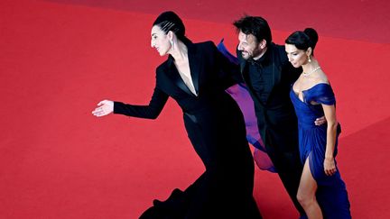 Une fois de plus, Rossy De Palma, présidente de la Caméra d'or enflamme le tapis rouge pour le plus grand plaisir des photographes. Elle est aux côtés de deux autres membres du jury, Samuel Le Bihan et Stefania Cristian. (CHRISTOPHE SIMON / AFP)