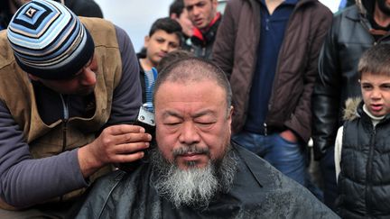 Séance de coiffure pour Ai Weiwei à Idomeni, en Grèce, auprès des migrants, le 17 mars 2016
 (Sakis Mitrolidis / AFP)