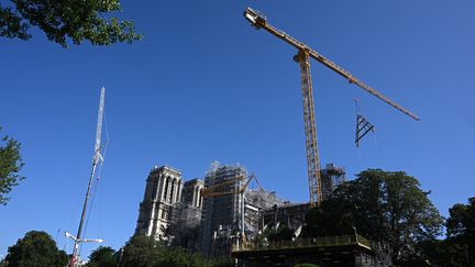 Une partie de la charpente en bois est grutée jusqu'à la cathédrale Notre-Dame de Paris lors de sa restauration, à Paris le 11 juillet 2023. (STEFANO RELLANDINI / AFP)