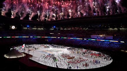 Sous les feux d'artifice et les multiples films d'animation de la cérémonie d'ouverture, les athlètes se sont regroupés au centre de l'enceinte.&nbsp;Le drapeau olympique a ensuite fait son entrée au milieu des délégations internationales présentes dans le Stade national olympique. (JEFF PACHOUD / AFP)