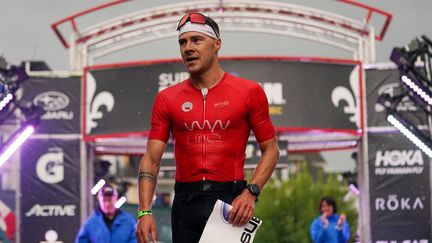 Le triathlète américain Collin Chartier lors son sacre à l'Ironman Mont-Tremblant, le 21 août 2022. (ALEX BIERENS DE HAAN / AFP)