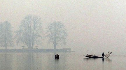 Un p&ecirc;cheur cachemiri &nbsp;jette son filet dans les eaux du lac Dal &agrave; Srinagar (Inde), le 4 janvier 2012. (FAYAZ KABLI / REUTERS)