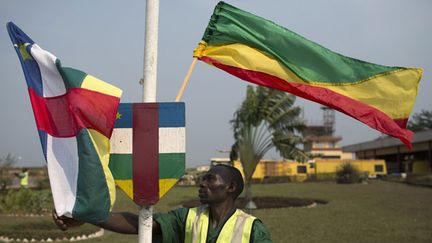 &nbsp; (Un employé congolais fixe des drapeaux de Centrafrique et de République du Congo pour célébrer l'accord de Brazzaville. © REUTERS/Siegfried Modola)