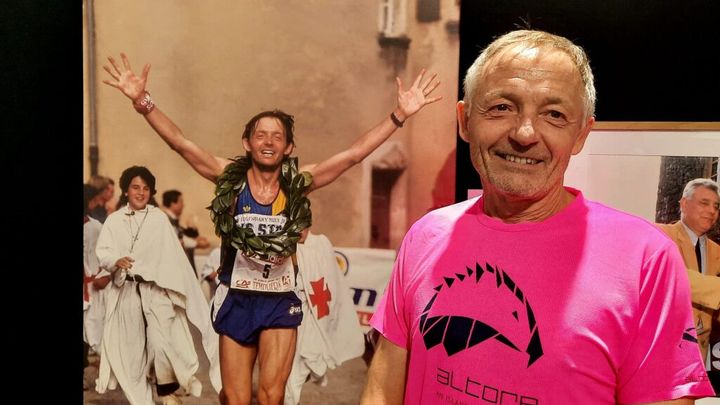 Patrick Renard, premier vainqueur des Templiers en 1995, pose devant sa photo de l'époque. Octobre 2024 (JEROME VAL / RADIO FRANCE)