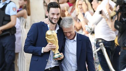 Hugo Lloris et Didier Deschamps avec le trophée de la Coupe du monde, le 16 juillet 2018 à Paris. (LIONEL BONAVENTURE / AFP)