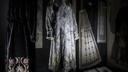 À travers une centaine de vêtements issus du fonds Galliera, du Museo del Traje à Madrid et du Museo Fortuny à Venise, l’exposition "Fortuny, un Espagnol à Venise"dévoile la diversité des inspirations et les talents d’inventeur de ce designer de mode. Le parcours dans les différentes salles du musée se fait dans une pénombre certaine : ces vêtements anciens sont abrités dans des armoires en glace, tout comme les textiles présentés, gâchant un peu le plaisir de la découverte. 
 (PHILIPPE LOPEZ / AFP)