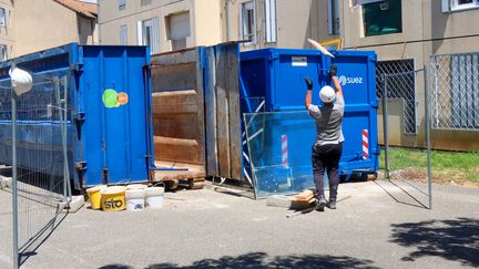 Un homme jette des déchets dans une poubelle, lors d'un chantier de réhabilitation de logements sociaux, à Valence (Drôme), le 18 juin 2020. (NICOLAS GUYONNET / HANS LUCAS / AFP)