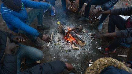 Des migrants soudanais tentent de se réchauffer autour d'un feu, le 28 décembre 2018 à Ouistreham (Calvados). (ARTUR WIDAK / NURPHOTO / AFP)