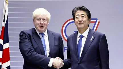 Boris Johnson, le premier ministre&nbsp;démissionnaire&nbsp;du Royaume-Uni serre la main de Shinzo Abe lors de la réunion au sommet du G7 à Biarritz (&nbsp;Pyrénées-Atlantiques),&nbsp;le 26 août 2019. (POOL FOR YOMIURI / YOMIURI / AFP)