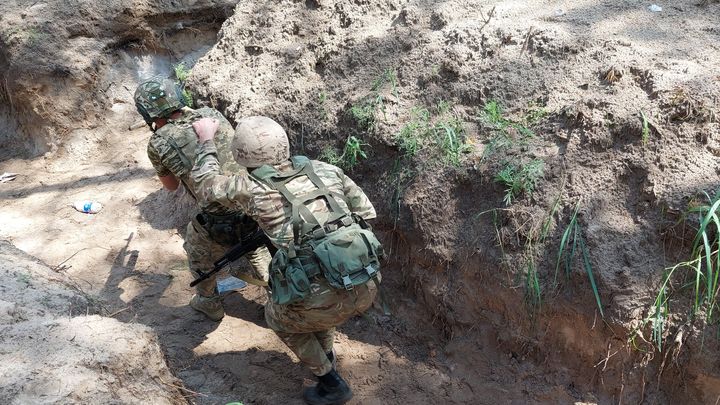 Des soldats de la 110e brigade d’infanterie de la défense territoriale s'entraînent à prendre une tranchée. (LAURENT MACCHIETTI / RADIO FRANCE)