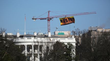 Des militants de Greenpeace, suspendus à une grue, déploient banderole antI-Trump