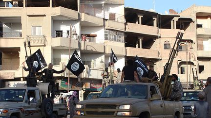 Des jihadistes du groupe Etat islamique paradent dans la ville de Raqqa, au nord de la Syrie, le 30 juin 2014. (WELAYAT RAQA / AFP)