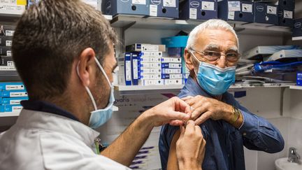 Un pharmacien vaccine un homme contre la grippe saisonnière à Ribérac (Dordogne), le 14 octobre 2020. (BURGER / PHANIE / AFP)