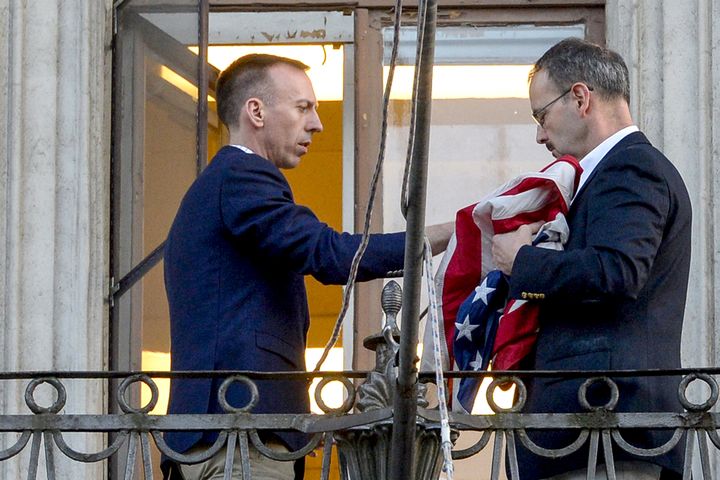 Des employés américains du consulat des Etats-Unis à Saint-Pétersbourg (Russie) retirent le drapeau, samedi 31 mars 2018. (OLGA MALTSEVA / AFP)