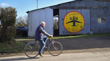Un homme à vélo devant une ferme opposée à l'aéroport de Notre-Dame-des-Landes, en Loire-Atlantique, le 17 janvier 2018. (LOIC VENANCE / AFP)