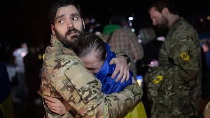 Une femme est enlacée par un soldat lors d'un échange de prisonnières entre l'Ukraine et la Russie, le 17 octobre 2022, dans un lieu tenu secret. (CABINET DE LA PRESIDENCE UKRAINIENNE / ANADOLU AGENCY / AFP)