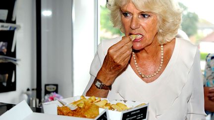 Camilla, duchesse de Cornouailles mange des "fish and chips" lors d'une visite &agrave; Bridlington (Royaume-Uni), le 23 juillet 2013. (REUTERS)