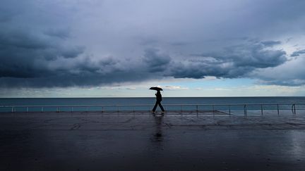 Une personne marche le long de la Promenade des Anglais, à Nice (Alpes-Maritimes), le 23 avril 2024. (VALERY HACHE / AFP)