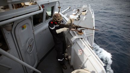 Un marin à bord du navire "Commandant Birot" de la marine française, tire avec une mitrailleuse sur une cible lors d'un exercice d'entraînement dans le golfe de Guinée, au large du port de Tema, près d'Accra, le 20 février 2014.&nbsp; (CHRIS STEIN / AFP)