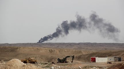 De la fumée s'élève à la suite de l'opération des milices chiites et des forces irakiennes contre l'Etat islamique, entre Hamrin et Saladin (Irak), le 8 avril 2015. (HAYDAR HADI / ANADOLU AGENCY / AFP)