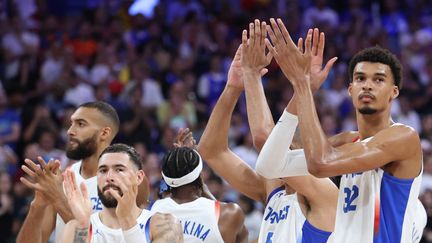 La déception des joueurs de l'équipe de France hommes de basketball après leur défaite contre l'Allemagne en phase de groupes des Jeux olympiques, le 2 août à Villeneuve d'Ascq (THOMAS COEX / AFP)