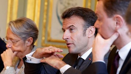 Le président de la République, Emmanuel Macron, entouré de la Première ministre Elisabeth Borne et du ministre du Travail, Olivier Dussopt, au palais de l'Elysée (Paris), le 18 avril 2023. (STEPHANIE LECOCQ / POOL VIA AFP)