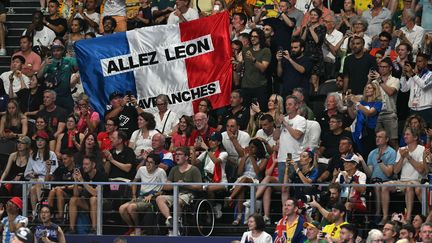 Les supporters de Léon Marchand réagissent lors de la finale du 200 m brasse hommes des Jeux olympiques de Paris à l'Arena Paris La Défense à Nanterre, le 31 juillet 2024. (OLI SCARFF / AFP)