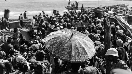 des milliers de migrants saisonniers arrivent de tous les principaux villages de pêche sénégalais (Mbour, Saint-Louis, Joal, Dakar) à Kayar. Sur la plage, tout le monde vient prendre l’air, regarder les pêcheurs décharger, acheter du poisson, vendre des bijoux, du tissu ou encore du café.  (Nathalie Guironnet)