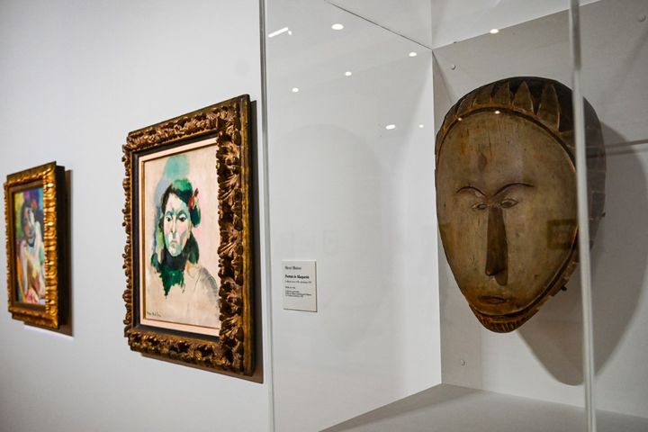 "Portrait de Marguerite" d'Henri Matisse et un masque en bois, dans l'exposition "Devenir Matisse, ce que les maîtres ont de meilleur" au Musée Matisse du&nbsp;Cateau-Cambrésis (Nord). (DENIS CHARLET / AFP)