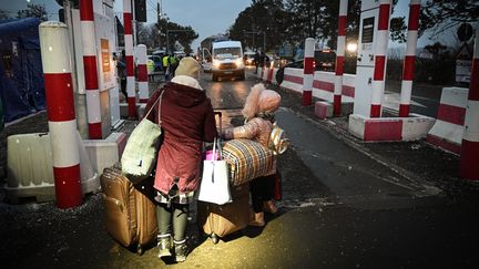 Une famille ukrainienne en train de franchir la frontière avec la Roumanie pour fuir l'invasion russe, le 1er mars 2022. (DANIEL MIHAILESCU / AFP)