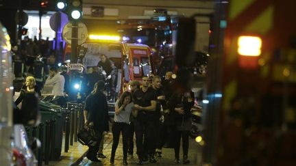 Les pompiers portent assistance aux premières victimes et aux témoins des attaques, sous le choc, dans le 10e arrondissement de Paris. (KENZO TRIBOUILLARD / AFP)