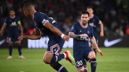 Lionel Messi sert Kylian Mbappé lors du match entre le PSG et l'OL, le 19 septembre (FRANCK FIFE / AFP)