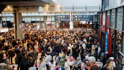 Des voyageurs dans le hall de la gare Montparnasse, à Paris, après des retards liés à une panne provoquée par la foudre, le 28 juillet 2023. (ENZO SULTAN / LE PARISIEN / MAXPPP)